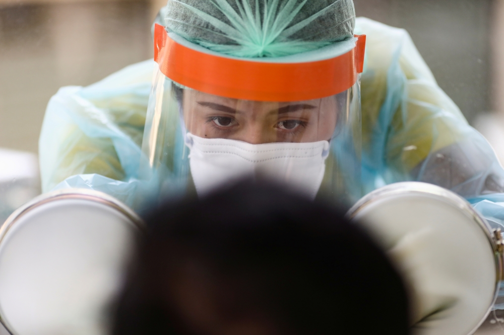 A medical personnel performs a nose swab test on a local resident of a community in Bangkok, amid the coronavirus disease (COVID-19) outbreak in Thailand, April 28, 2020. REUTERS/Athit Perawongmetha/File Photo