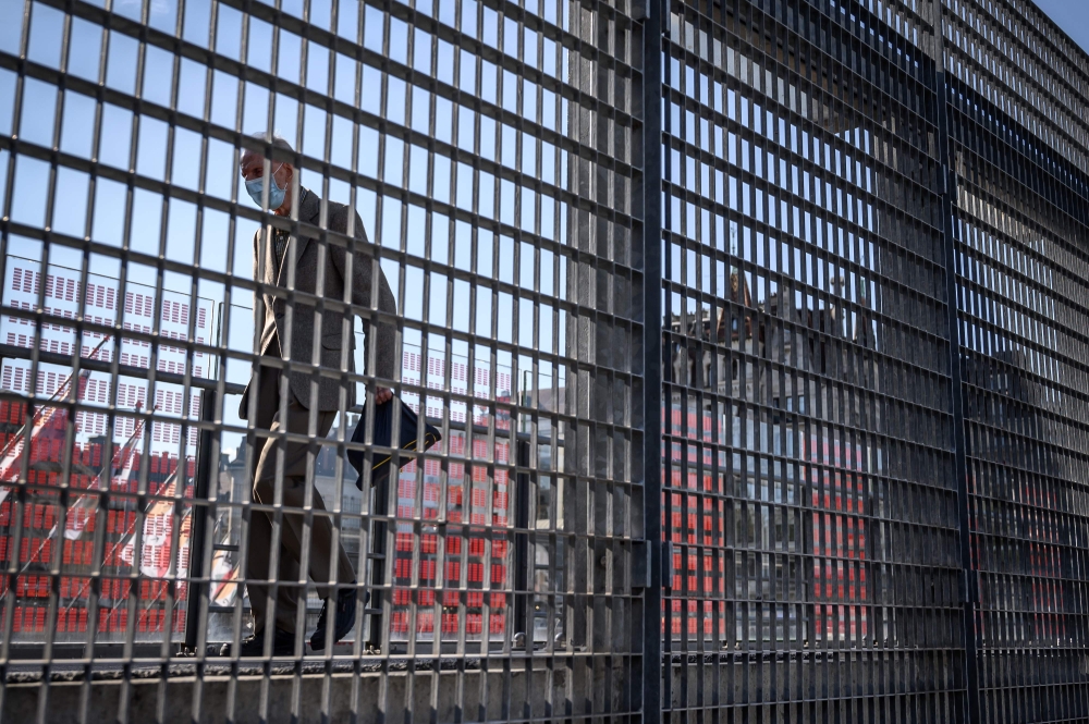 An elderly man wearing a protective face mask walks in a street in Lausanne on August 18, 2020, amid the COVID-19 outbreak, caused by the novel coronavirus. / AFP / Fabrice COFFRINI