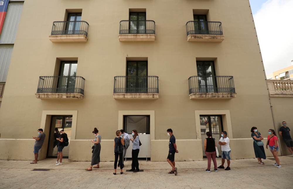 People queue to get tested for the coronavirus disease (COVID-19) in Hospitalet del Llobregat, near Barcelona, Spain, August 21, 2020. REUTERS/Albert Gea