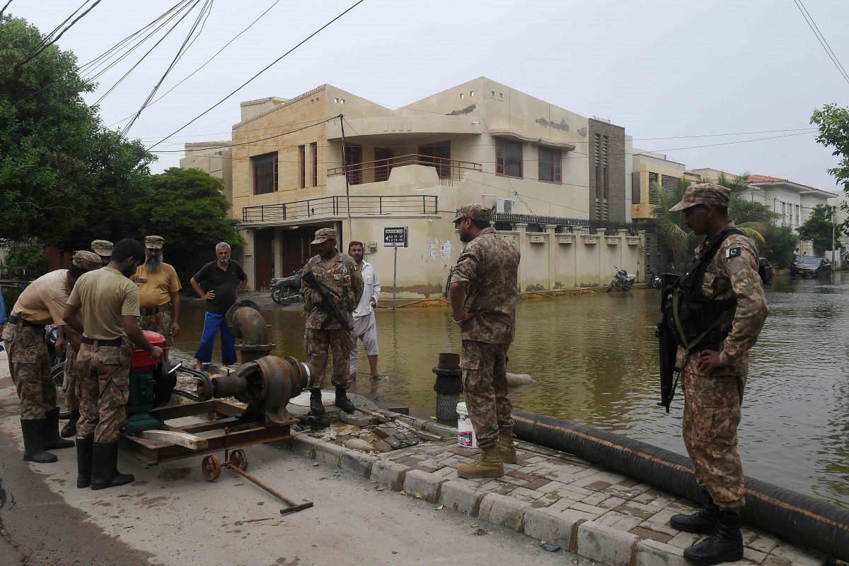 Troops install a water pump to remove water from a flooded residential area following heavy monsoon rains triggered floods in Pakistan's port city of Karachi on August 31, 2020./ AFP / Asif HASSAN