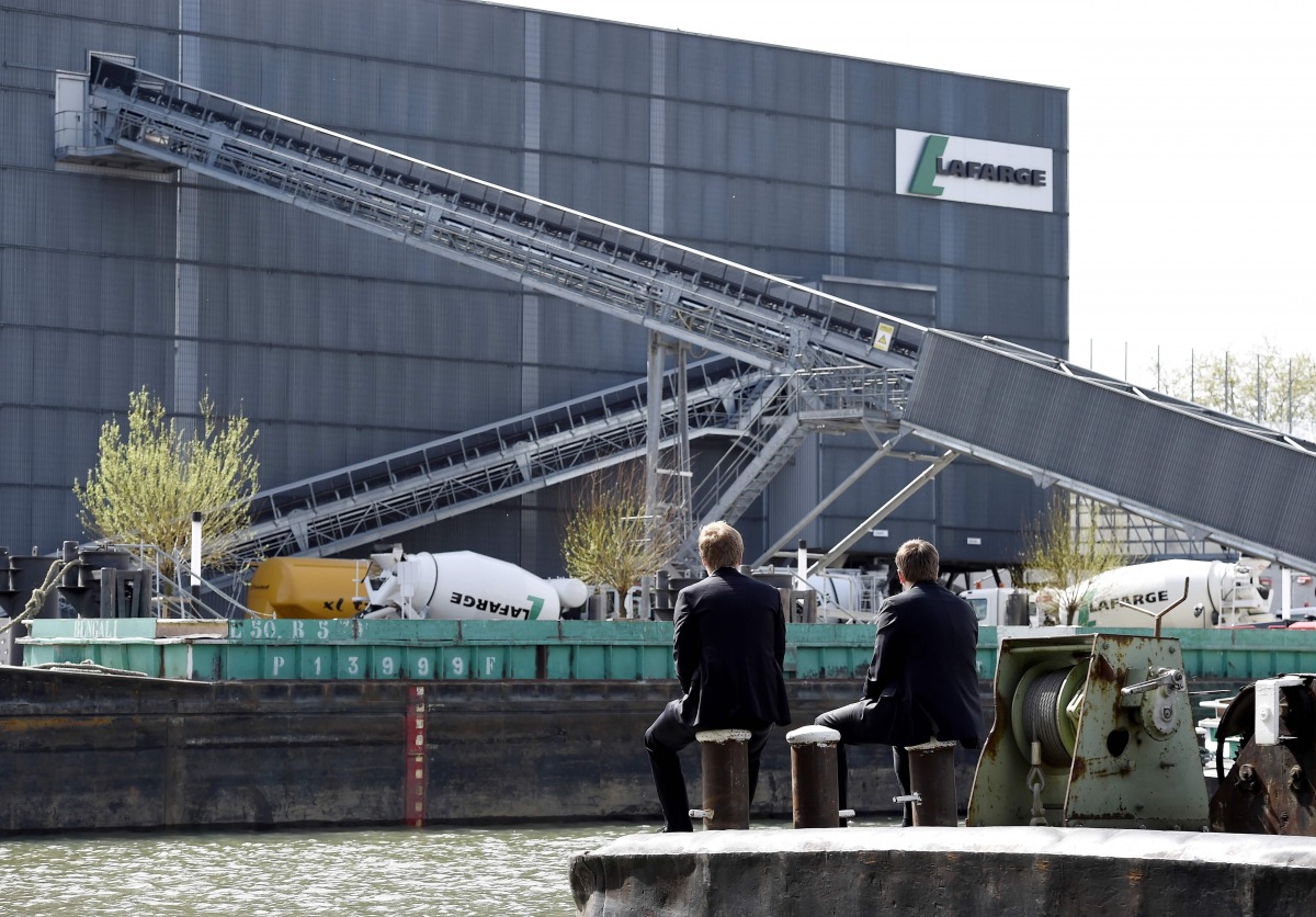 (FILES) This file photo taken on April 7, 2014 shows people sitting along the river, across from the French cement company Lafarge-Holcim, in Paris. / AFP / Franck FIFE