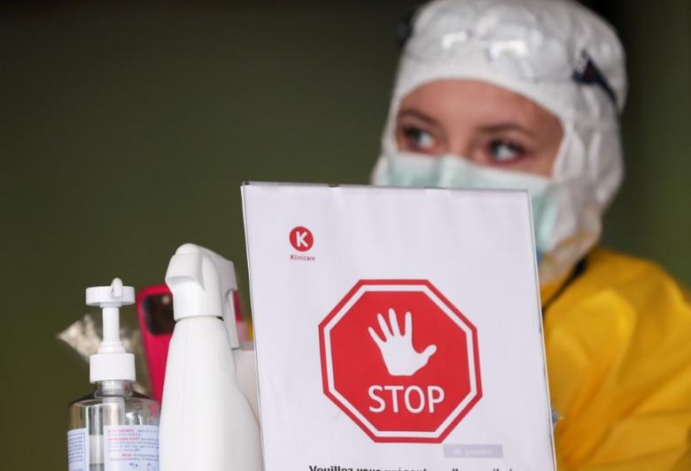 FILE PHOTO: An employee at Klinicaire medical center waits at the entrance of a checking area set to examine patients suffering from coronavirus (COVID-19) symptoms in Brussels, Belgium March 27, 2020. REUTERS/Yves Herman

