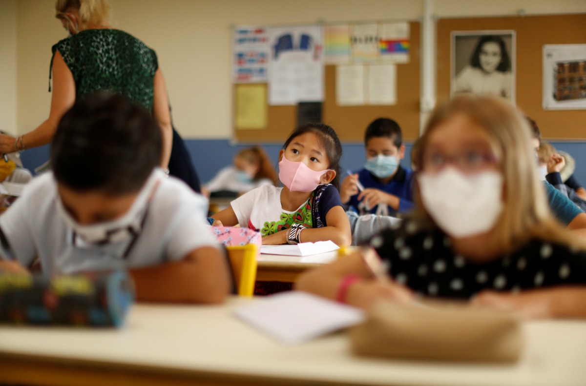 Secondary school students, wearing protective face masks, work in a classroom at the College Henri Matisse school during its reopening in Nice as French children return to their schools after the summer break with protective face masks and social distanci