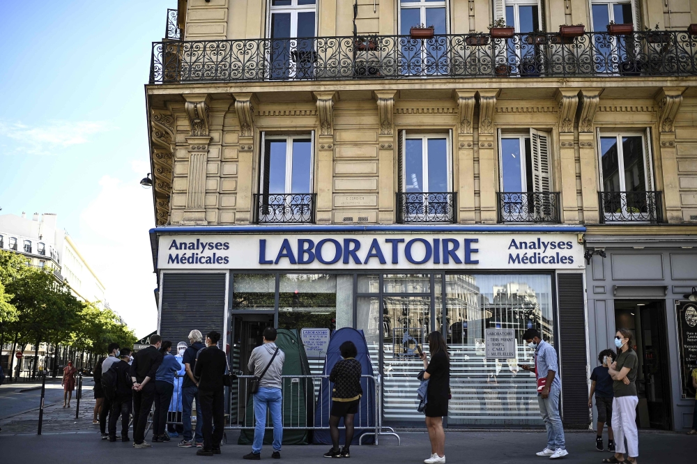 People stand in a queue as they wait for a PCR test for the novel coronavirus at a medical laboratory in Paris amids the Covid-19 pandemic on September 4, 2020. / AFP / Christophe ARCHAMBAULT