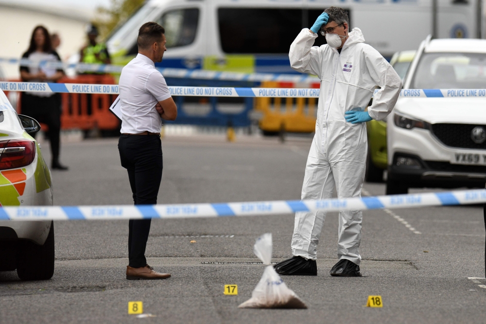 Police forensics officers gather evidence near to evidence markers inside a cordon on Irving Street, following a major stabbing incident in the centre of Birmingham, central England, on September 6, 2020.  AFP / Oli SCARFF