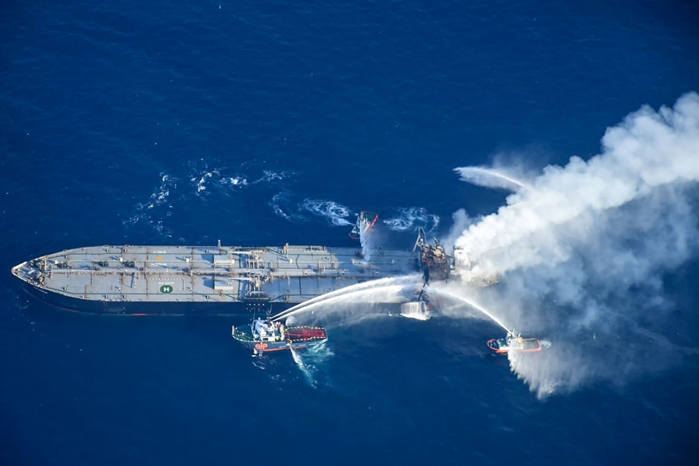 This handout photograph taken on September 6, 2020, and released by Sri Lanka's Air Force shows fireboats battling to extinguish a fire on the Panamanian-registered crude oil tanker New Diamond, some 60 kms off Sri Lanka's eastern coast where a fire was r