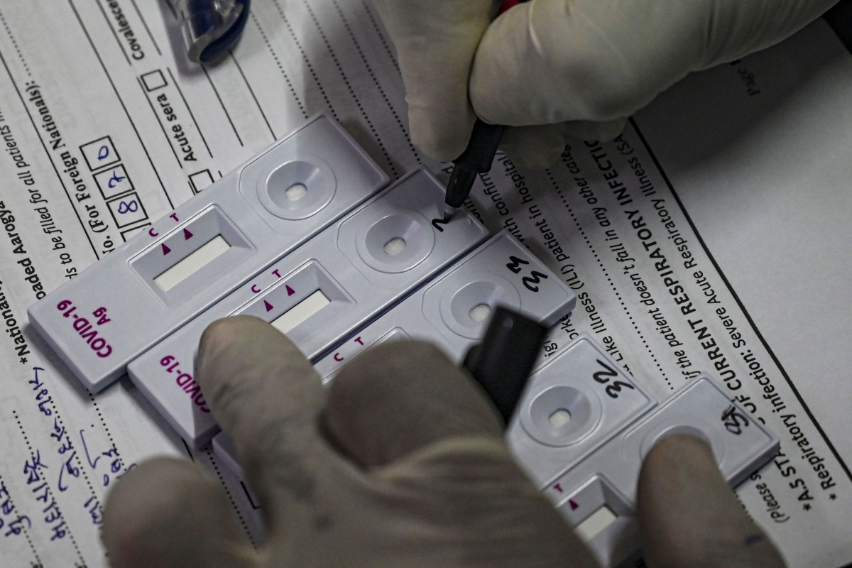 A health worker marks a number on a rapid antigen test kit during a Covid-19 coronavirus screening for frontline civic staff in Mumbai on September 10, 2020. / AFP / INDRANIL MUKHERJEE
