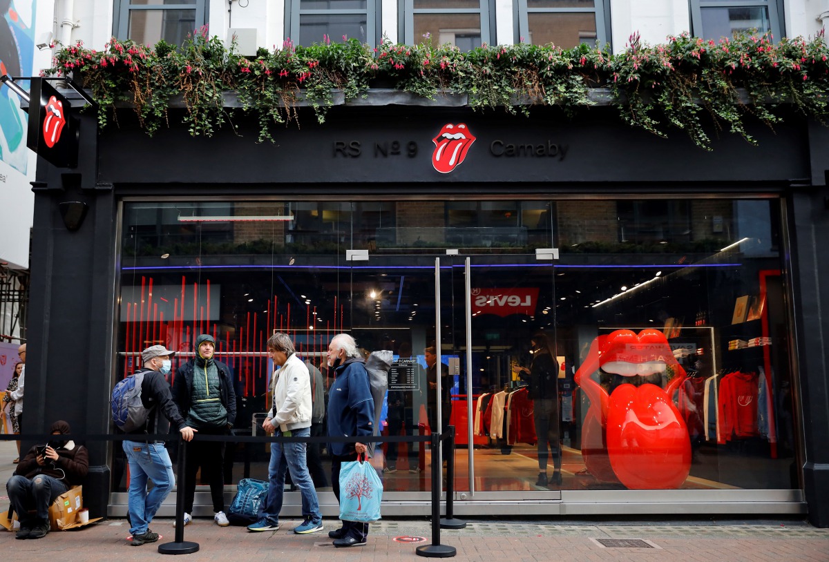 People queue to enter The Rolling Stones new flagship store in London on September 9, 2020, ahead of it's first day of opening.  / AFP / Tolga Akmen
