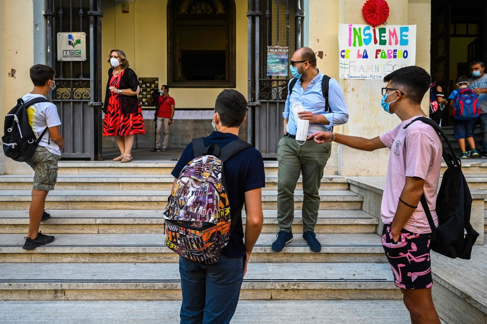 Pupils wearing a face mask arrive on September 14, 2020 for the start of the school year at the Luigi Einaudi technical high school in Rome, during the the COVID-19 infection, caused by the novel coronavirus.  AFP / Vincenzo PINTO