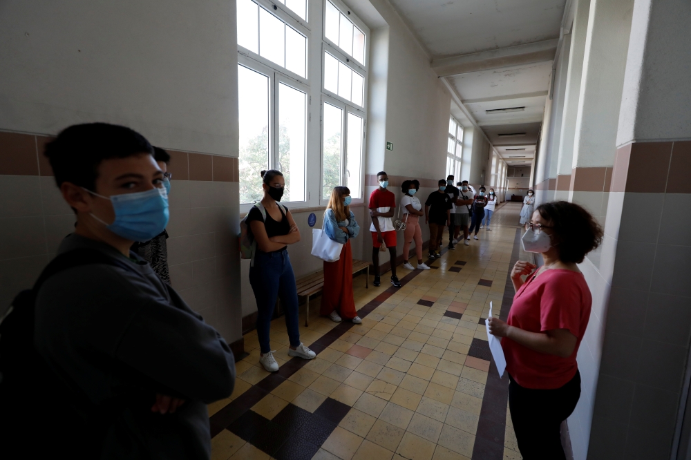 Students wearing protective face masks attend their first day of classes at Maria Amalia Vaz de Carvalho High School, as high school students return to schools under strict restrictions, amid the coronavirus disease (COVID-19) outbreak, in Lisbon, Portuga