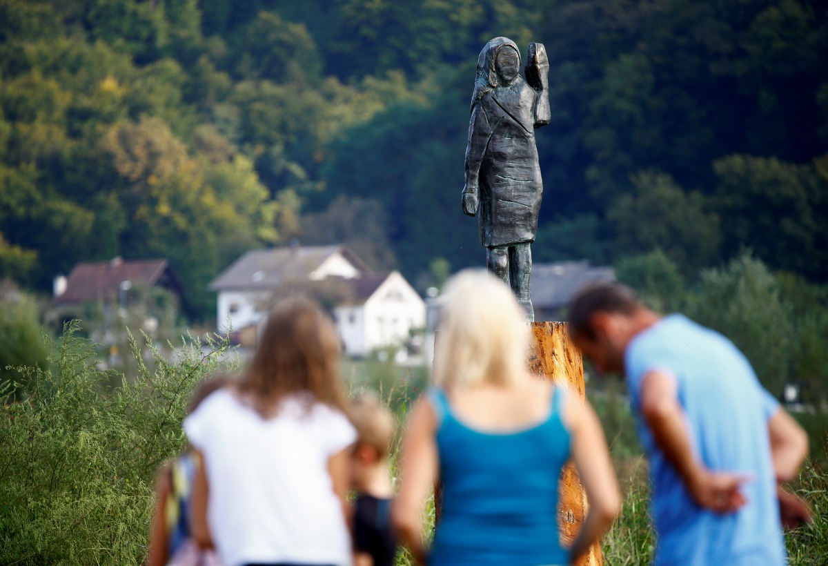 People look at the new bronze statue of U.S first lady Melania Trump in Rozno, near her hometown of Sevnica, Slovenia, September 15, 2020. REUTERS/Borut Zivulovic
