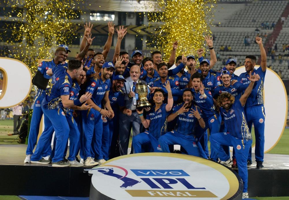 (FILES) In this file photo taken on May 13, 2019, Mumbai Indians team players hold the trophy as they celebrate their victory against Chennai Super Kings after the 2019 Indian Premier League (IPL) Twenty20 final cricket match at the Rajiv Gandhi Internati