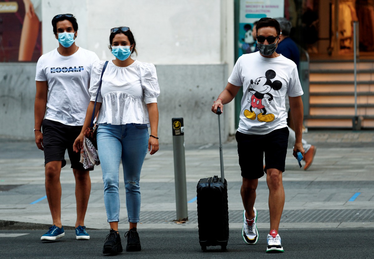 FILE PHOTO: People wearing protective face masks cross the street amid the coronavirus disease (COVID-19) outbreak in Madrid, Spain July 28, 2020. REUTERS/Javier Barbancho/File Photo
