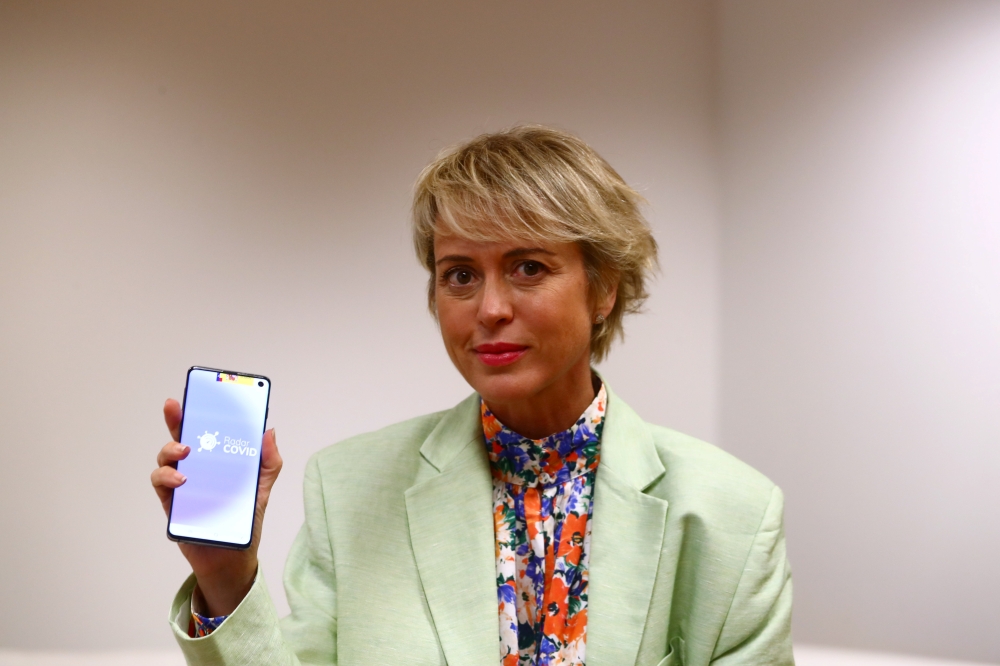 Carme Artigas, head of Spain's state digital and artificial intelligence unit, poses holding a mobile phone with the Radar Covid app before an interview with Reuters in Madrid, September 16, 2020. REUTERS/Sergio Perez