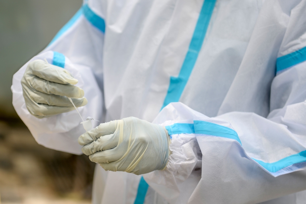 A health worker collects a swab sample from a resident for a Covid-19 coronavirus test at a public health centre in Hyderabad on September 17, 2020. / AFP / NOAH SEELAM
