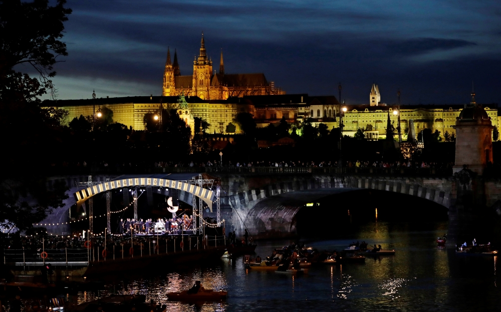 People watch a classical concert on a floating stage on Vltava river as the spread of the coronavirus disease (COVID-19) continues in Prague, Czech Republic, September 19, 2020. REUTERS/David W Cerny
 