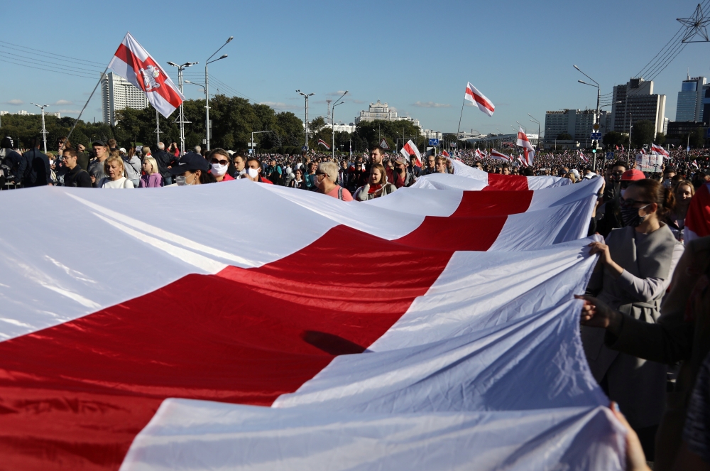 Opposition supporters carry a historical white-red-white flag of Belarus as they take part in a rally to demand the resignation of Belarusian President Alexander Lukashenko more than a month after the disputed presidential election, in Minsk, Belarus Sept