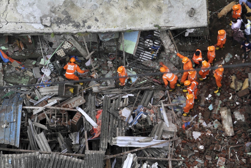 Rescue workers search for survivors in the rubble of a collapsed three-storey residential building in Bhiwandi on September 21, 2020. Ten people were killed and up to 25 were feared trapped after a three-storey residential building collapsed before dawn o