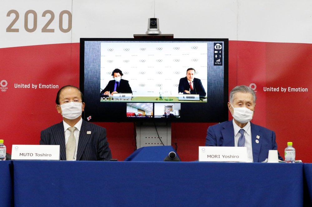 Christophe Dubi, IOC's Olympic Games Executive Director, and Robert Roxburgh, Head of Olympic Games Communications of IOC, are seen on screen during a joint press conference between the International Olympic Committee (IOC) and Tokyo Organising Committee 