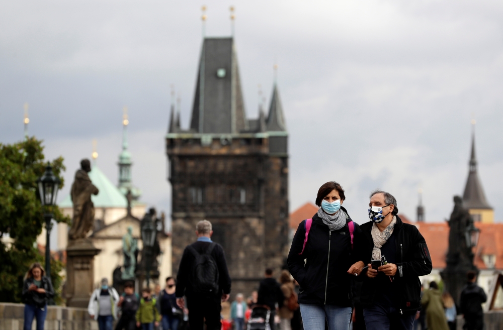 People wearing face masks walk across the medieval Charles Bridge as the spread of the coronavirus disease (COVID-19) continues in Prague, Czech Republic, September 25, 2020. REUTERS/David W Cerny