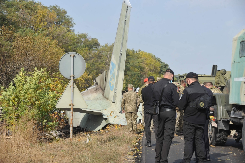 Military and experts work on the place of the Antonov-26 transport aircraft crash at Chuhuiv military air base around 30 kilometers southeast of Kharkiv on September 26, 2020.  AFP / SERGEY BOBOK
