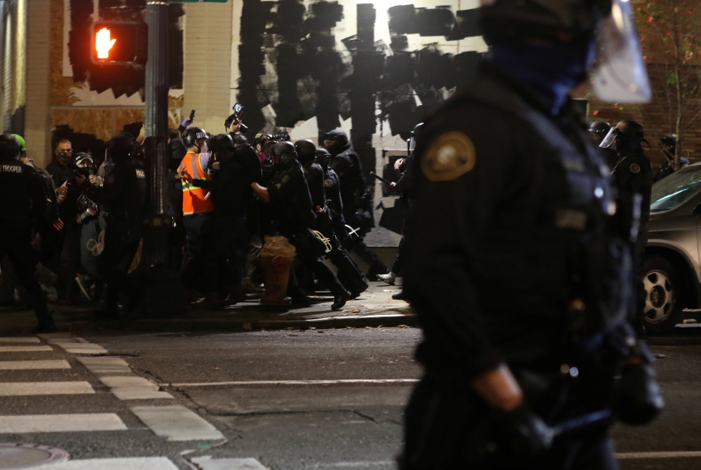 Law enforcement officers push members of the media covering a protest against police violence and racial inequality during unrest in Portland, Oregon, U.S. September 26, 2020. Picture taken September 26, 2020. REUTERS/Jim Urquhart
