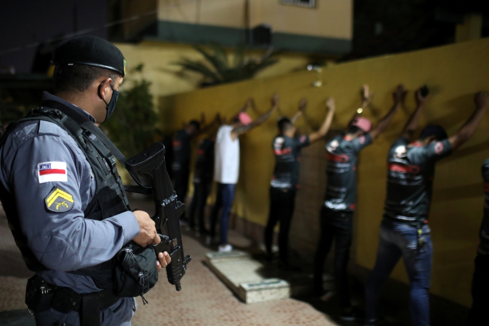A police officer checks people during an operation against a clandestine party, amid the coronavirus disease (COVID-19) outbreak in Manaus, Brazil, September 25, 2020. Picture taken September 25, 2020. REUTERS/Bruno Kelly
