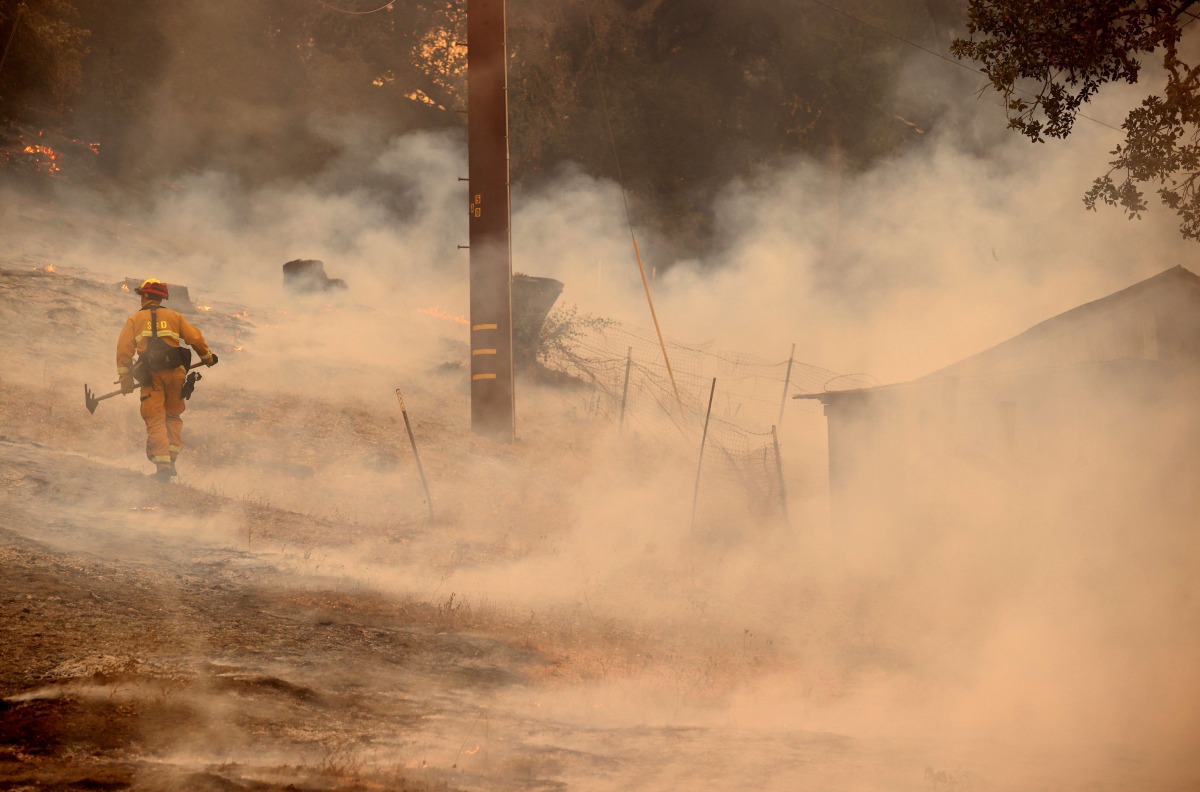 ST HELENA, CALIFORNIA - SEPTEMBER 27: A firefighter walks through smoke as he battles the Glass Fire on September 27, 2020 in Napa, California. Justin Sullivan/AFP
