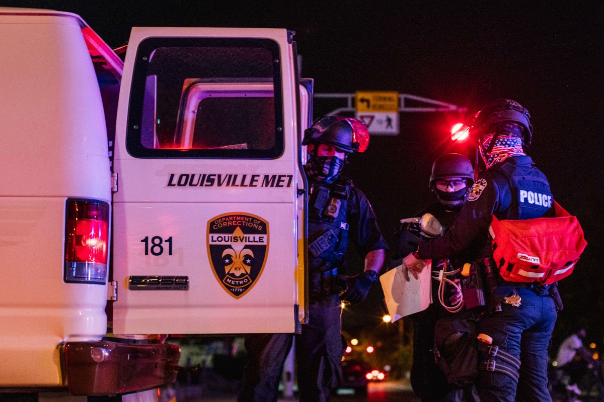LOUISVILLE, KY - SEPTEMBER 26: Police officers put a protestor in the back of a police vehicle on September 26, 2020 in Louisville, Kentucky. Mayor Greg Fischer mandated a city-wide curfew restricting protestors from gathering between the hours of 9 p.m. 