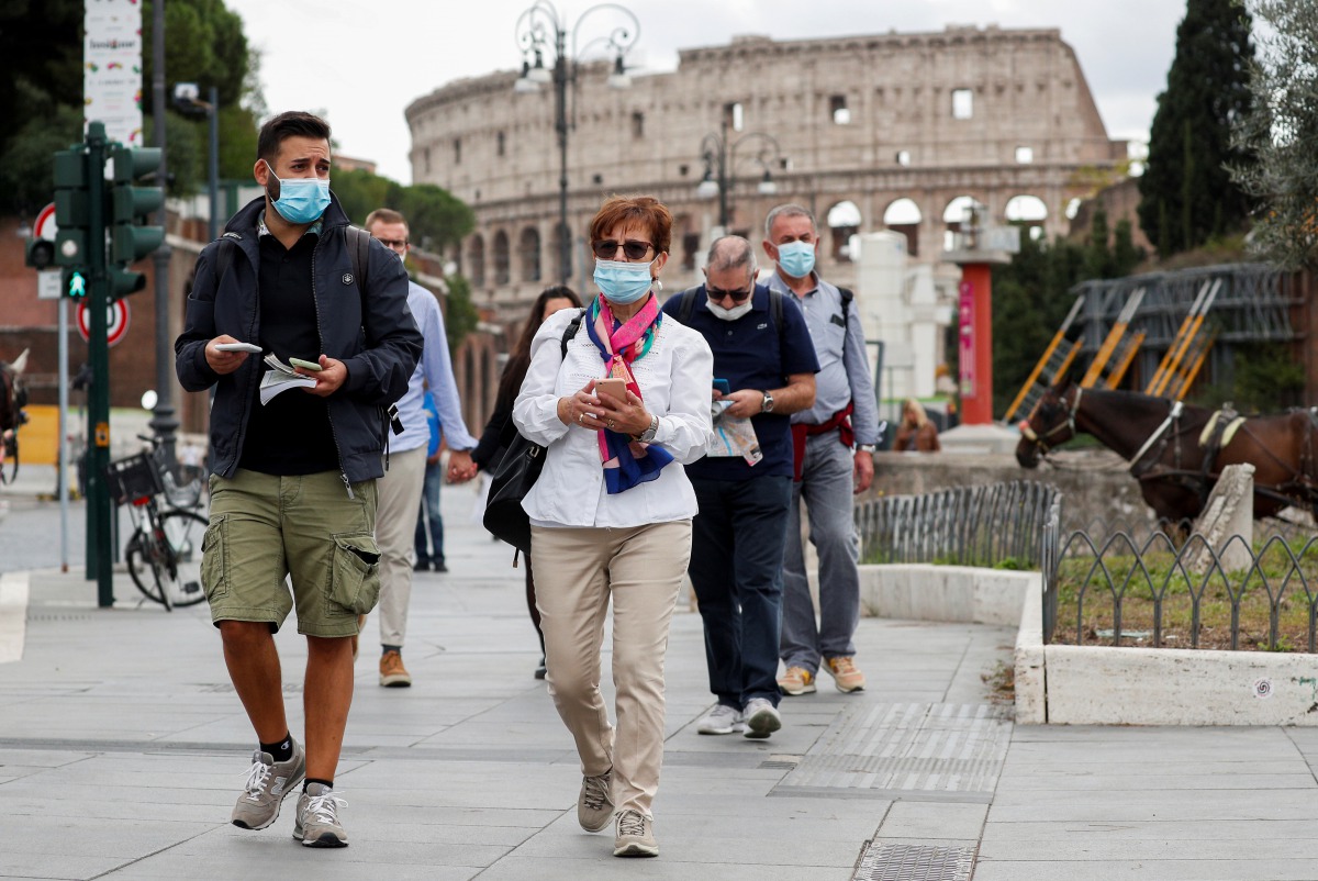 People wear face masks as local authorities in the Italian capital ROME order face coverings to be worn at all times out of doors in an effort to counter rising coronavirus disease (COVID-19) infections, in ROME, Italy October 2, 2020. REUTERS/Guglielmo M