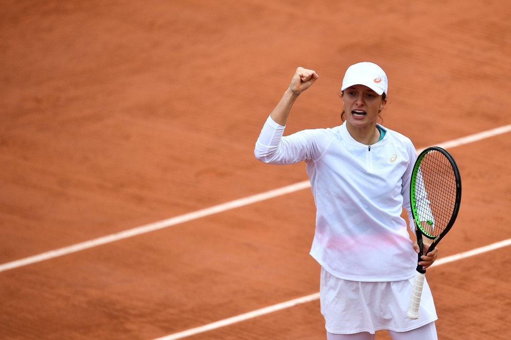 Poland's Iga Swiatek celebrates after winning a point against Canada's Eugenie Bouchard during their women's singles third round tennis match on Day 6 of The Roland Garros 2020 French Open tennis tournament in Paris on October 2, 2020. / AFP / Anne-Christ