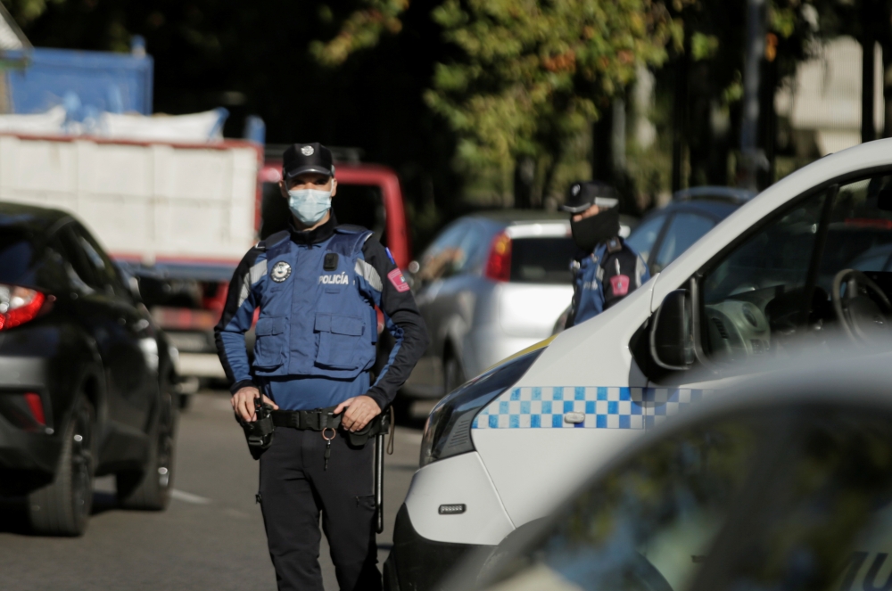 Police officers stand guard at a checkpoint during a partial lockdown amid the coronavirus disease (COVID-19) outbreak in Madrid, Spain, October 3, 2020. REUTERS/Javier Barbancho