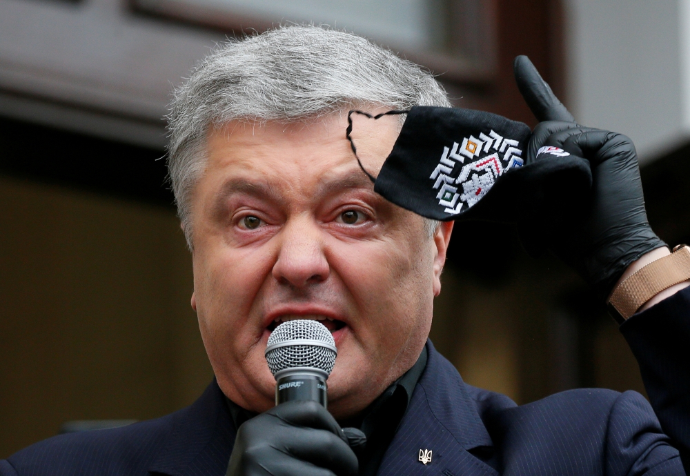 FILE PHOTO: Ukraine's former President Petro Poroshenko, who is suspected of abuse of office, holds a protective face mask while addressing journalists and his supporters before entering a court building in Kyiv, Ukraine June 18, 2020. REUTERS/Gleb Garani