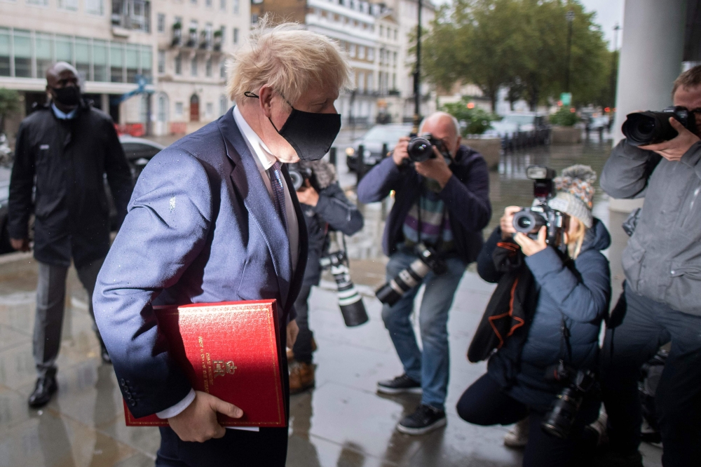 Britain's Prime Minister Boris Johnson wears a protective face covering as he arrives at the BBC in central London on October 4, 2020, to take part in the BBC political programme The Andrew Marr Show. AFP / JUSTIN TALLIS