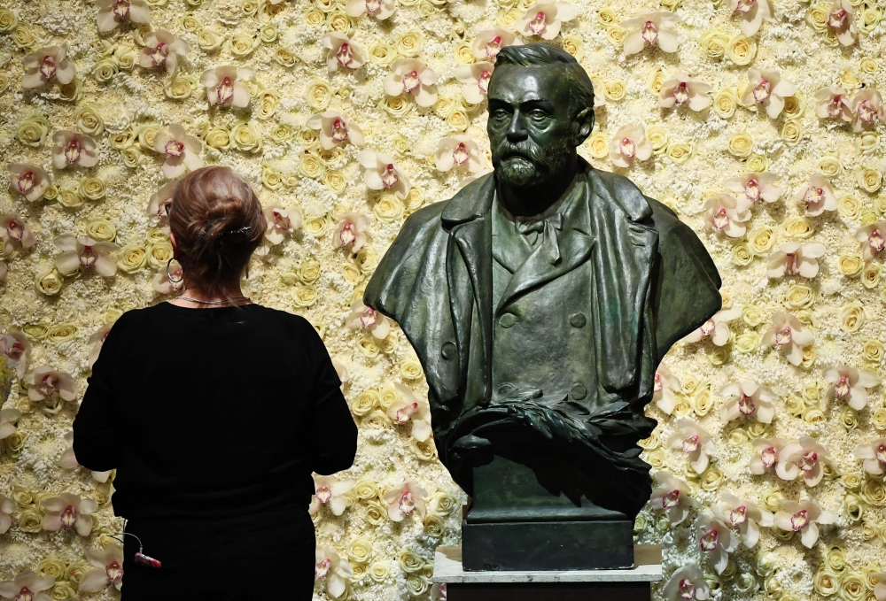 In this file photo taken on December 10, 2019 a visitor stands in front of a bust of the Nobel Prize founder, Alfred Nobel prior the Nobel awards ceremony at the Concert Hall in Stockholm, Sweden. Swedish inventor and scholar Alfred Nobel, who made a vast