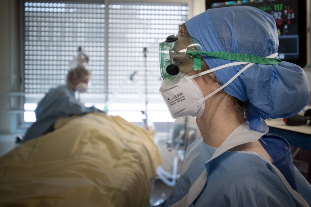 (FILES) In this file photo taken on April 27, 2020 Medical workers tend to a patient infected with COVID-19 at the intensive care unit of the Lariboisiere Hospital of the AP-HP (Assistance Publique - Hopitaux de Paris) in Paris. AFP / JOEL SAGET