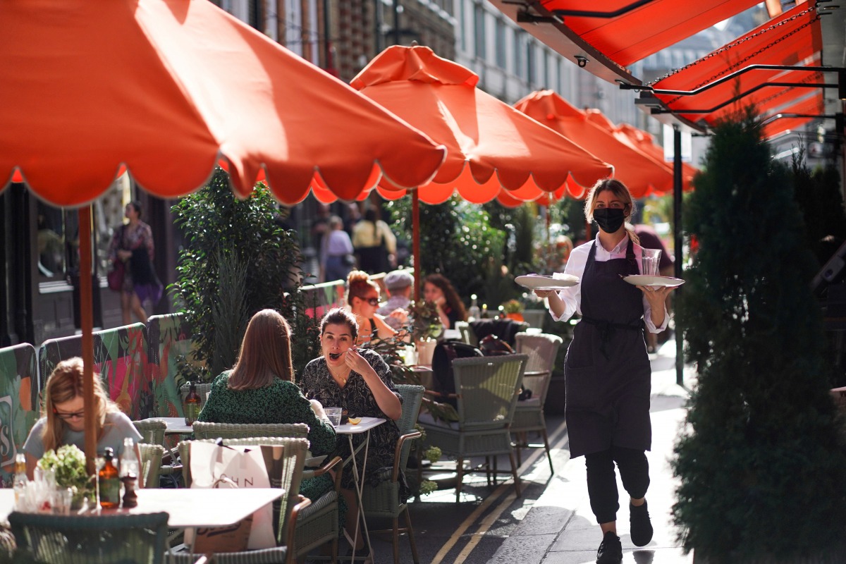FILE PHOTO: People sit at tables outside restaurants in Soho, amid the coronavirus disease (COVID-19) outbreak, in London, Britain, September 20, 2020. REUTERS/Henry Nicholls/File Photo
