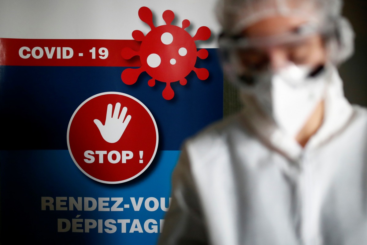 A health worker, wearing a protective suit and a face mask, works at a testing site for the coronavirus disease (COVID-19) in Nantes, France, October 6, 2020. REUTERS/Stephane Mahe
