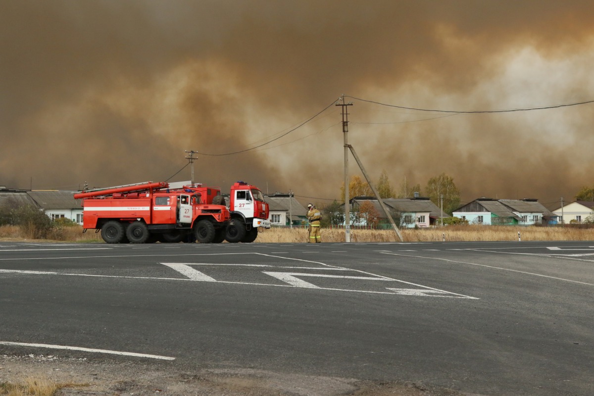 Fire trucks are seen on the road as smoke rises from the site of a fire at an ammunition depot in Ryazan Region, Russia October 7, 2020. Russian Emergencies Ministry in Ryazan Region/Handout via REUTERS 