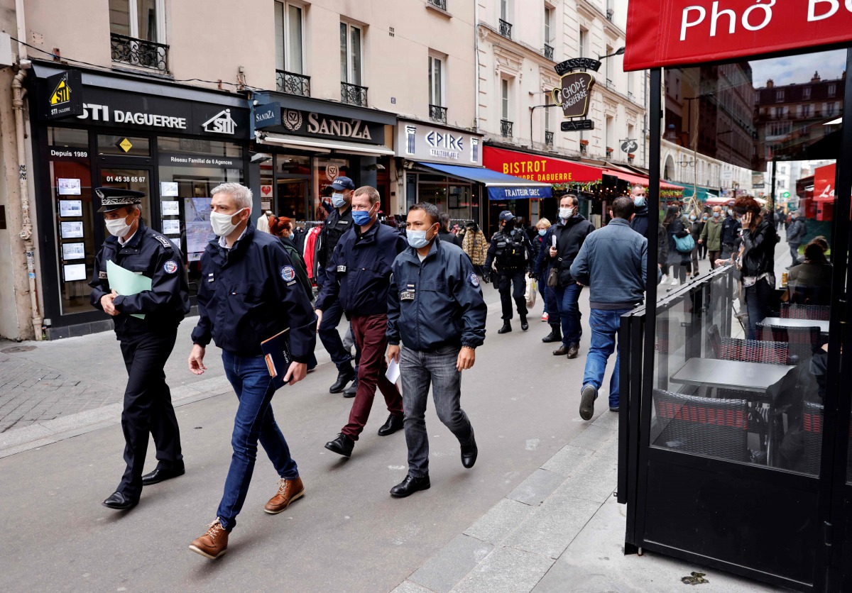 Police officers walk in a street with restaurants in Paris on October 6, 2020, during a patrol to inspect the implementation of new sanitary measures aimed at curbing the spread of the Covid-19 (novel coronavirus) outbreak in the French capital./ AFP / TH