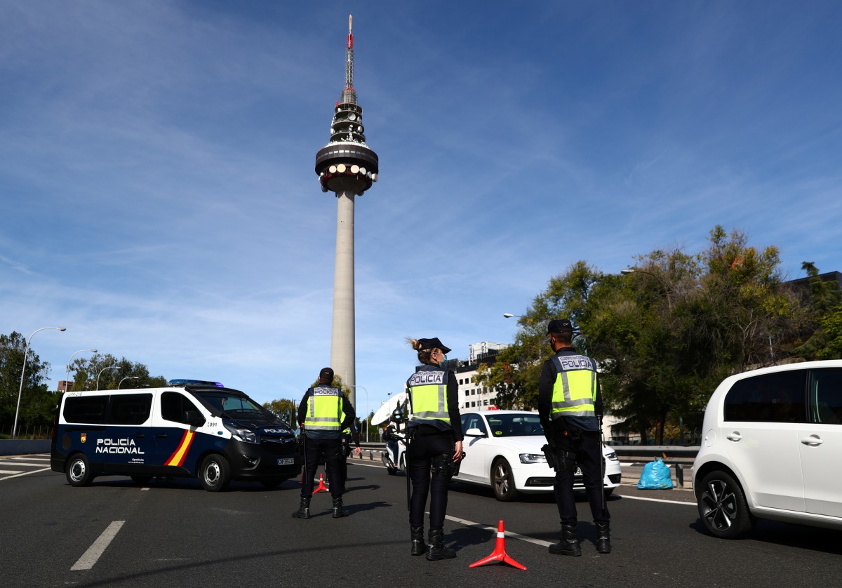 Spanish National Police officers wearing protective masks stand at a traffic checkpoint during a partial lockdown amid the outbreak of the coronavirus disease (COVID-19), in Madrid, Spain October 5, 2020. REUTERS/Sergio Perez
