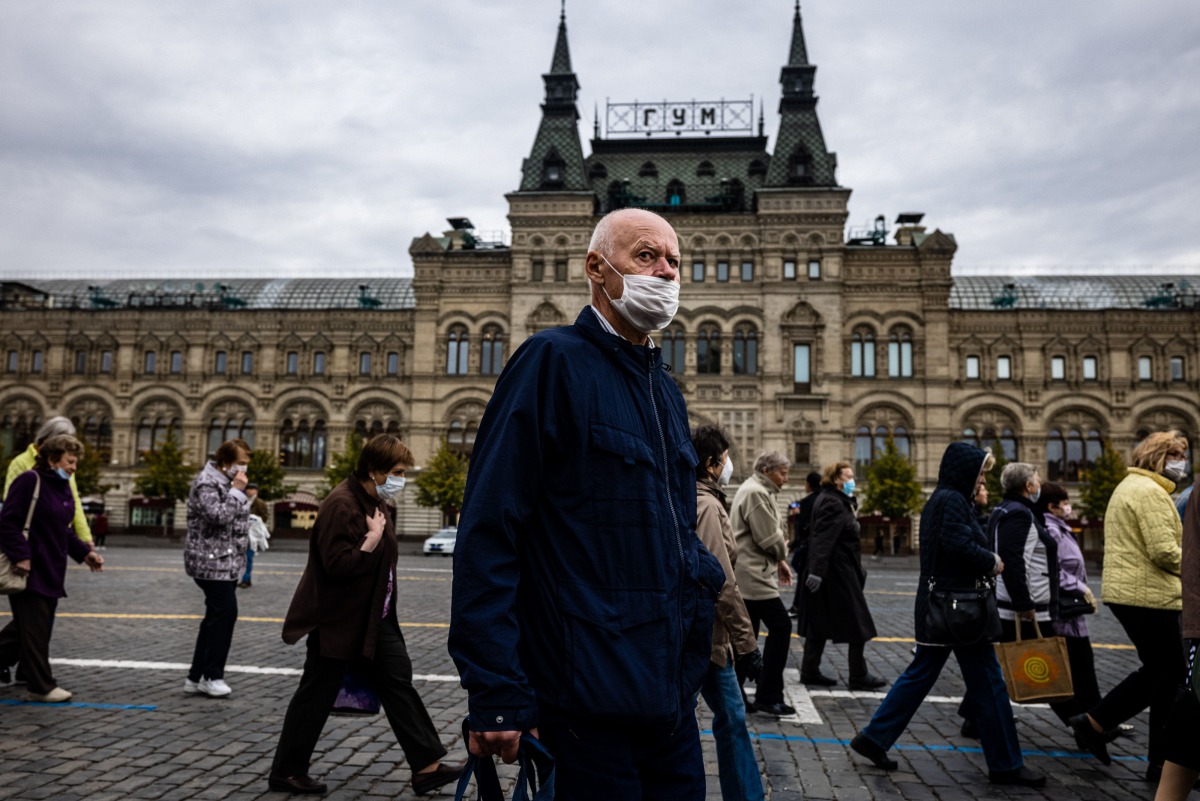 A man wearing a face mask to protect against the coronavirus disease walks on Red Square in front of the GUM department store in central Moscow on October 7, 2020. / AFP / Dimitar DILKOFF
