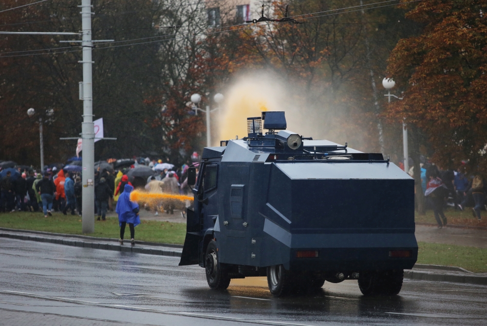Belarusian law enforcement members use a water cannon to disperse a crowd during an opposition rally to reject the presidential election results in Minsk, Belarus October 11, 2020. REUTERS/Stringer