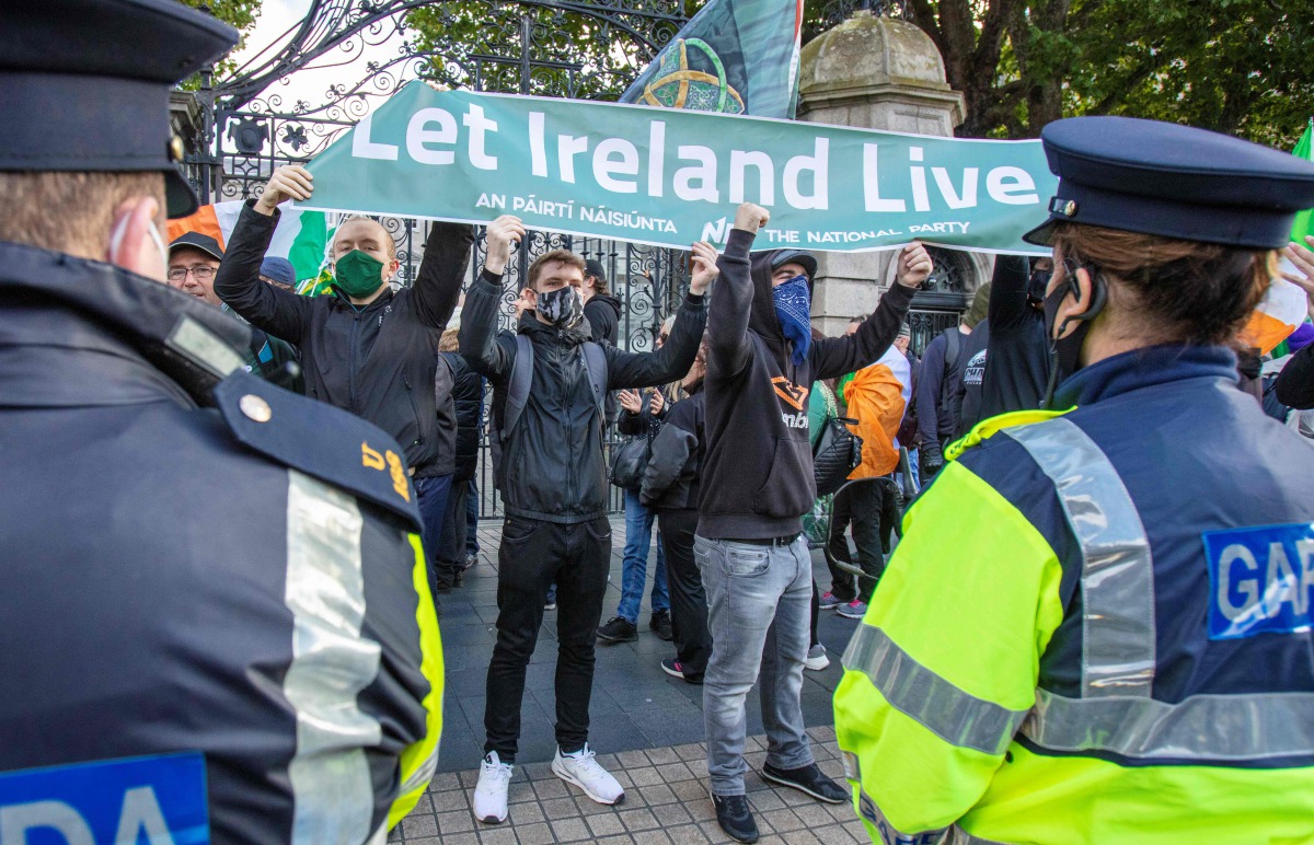 Demonstrators hold a banner during a protest against the Irish government imposed restrictions put in place to help stem the rise in the number of novel coronavirus COVID-19 cases, outside Leinster House in Dublin on October 10, 2020.
