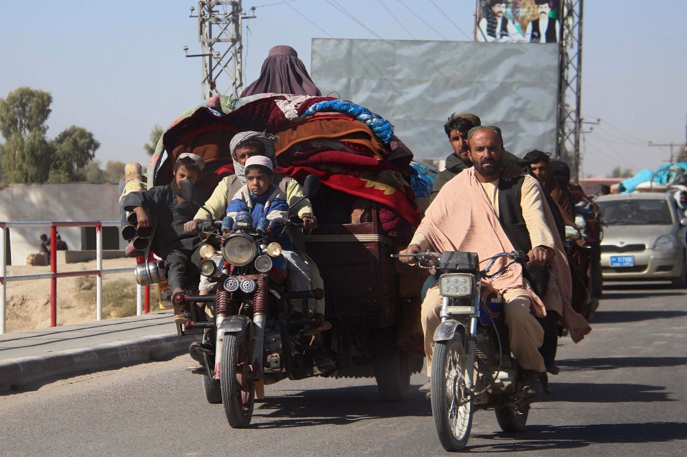 Afghan internally displaced people with their belongings flee from Nadali district to Lashkar Gah during the ongoing clashes between Taliban fighters and Afghan security forces, in Helmand province on October 12, 2020. / AFP / 