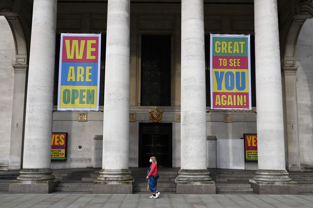 A pedestrian walks past the entrance to central library in Manchester, northwest England as the country battles a surge in coronavirus cases on October 19, 2020 / AFP / Paul ELLIS