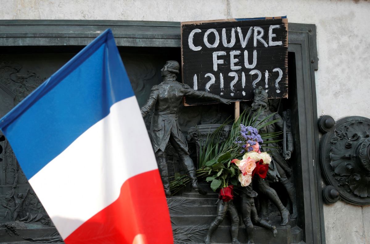 A placard against the late-night curfew is seen on the Republique statue, following the restrictions against the spread of the coronavirus disease (COVID-19) in Paris, France, October 18, 2020. REUTERS/Charles Platiau
