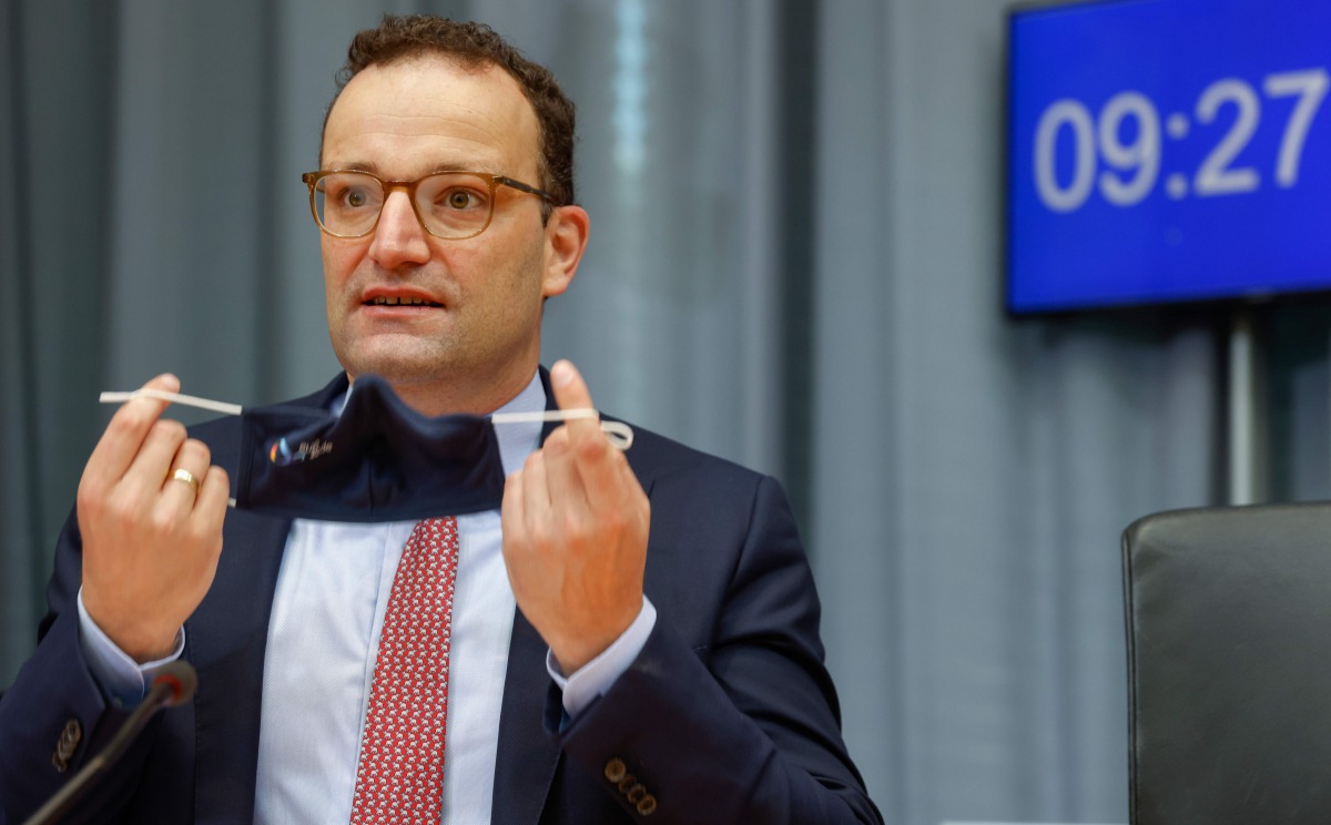 (FILES) In this file photo taken on September 22, 2020 German Health Minister Jens Spahn takes off his face mask as he takes his seat prior to a meeting of the Franco-German Parliamentary Assembly on September 22, 2020 in Berlin. German Health Minister Je