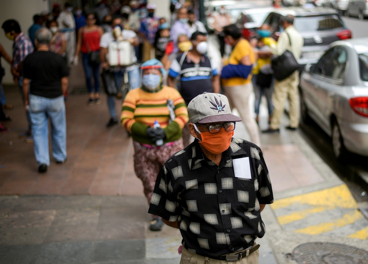 FILE PHOTO: People walk on a street in Guayaquil, Ecuador, in May, amid the outbreak of the coronavirus disease (COVID-19), May 20, 2020. REUTERS/Vicente Gaibor del Pino/File Photo
