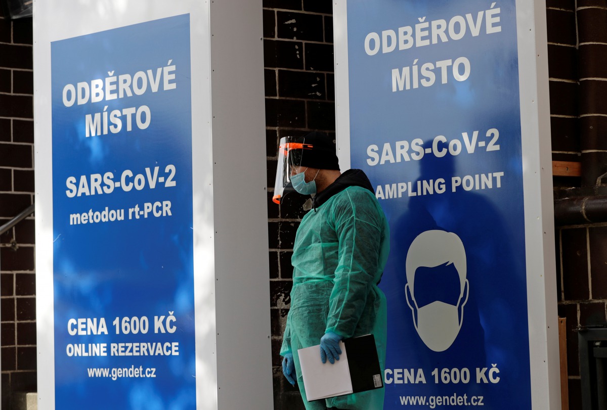 A medical staff member wearing a protective suit waits for people who will be tested for the coronavirus disease (COVID-19) in front of a recently opened sampling station inside of closed music club in Prague, Czech Republic, October 20, 2020. REUTERS/Dav